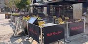 The exterior of Prezzo Bath, with black barriers displaying red text reading "pasta, pizza, vino"