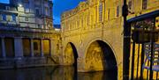 A close-up image of Pulteney Bridge in Bath's arches at night.