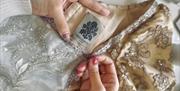 Close-up of a garment label with the Regency Life logo, on an intricately beaded dress.