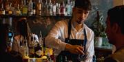 A bartender pouring a cocktail in The Bar at No.15 by GuestHouse, Bath.