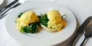 A plate of eggs benedict at the Parisian Brasserie restaurant in The Royal Hotel Bath