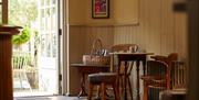 A wood pannelled room with wooden chairs and tables