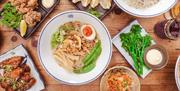 An overhead shot of ramen, tenderstem broccoli and other side dishes.