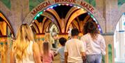Two families walking into the Mirror Maze at Wookey Hole Caves