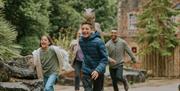 A family running through the Dinosaur Valley area at Wookey Hole Caves
