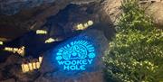 A graphic advertising Wookey Hole's annual Winter Wonderland projected as a light onto a cave wall.
