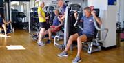 People using the fitness equipment inside the YMCA Bath Gym.