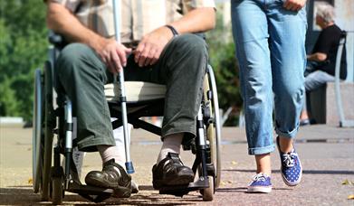 Person in Wheelchair next to Person walking