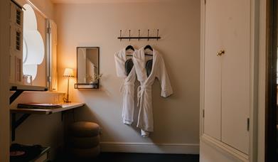 Hotel room with robes on a wall