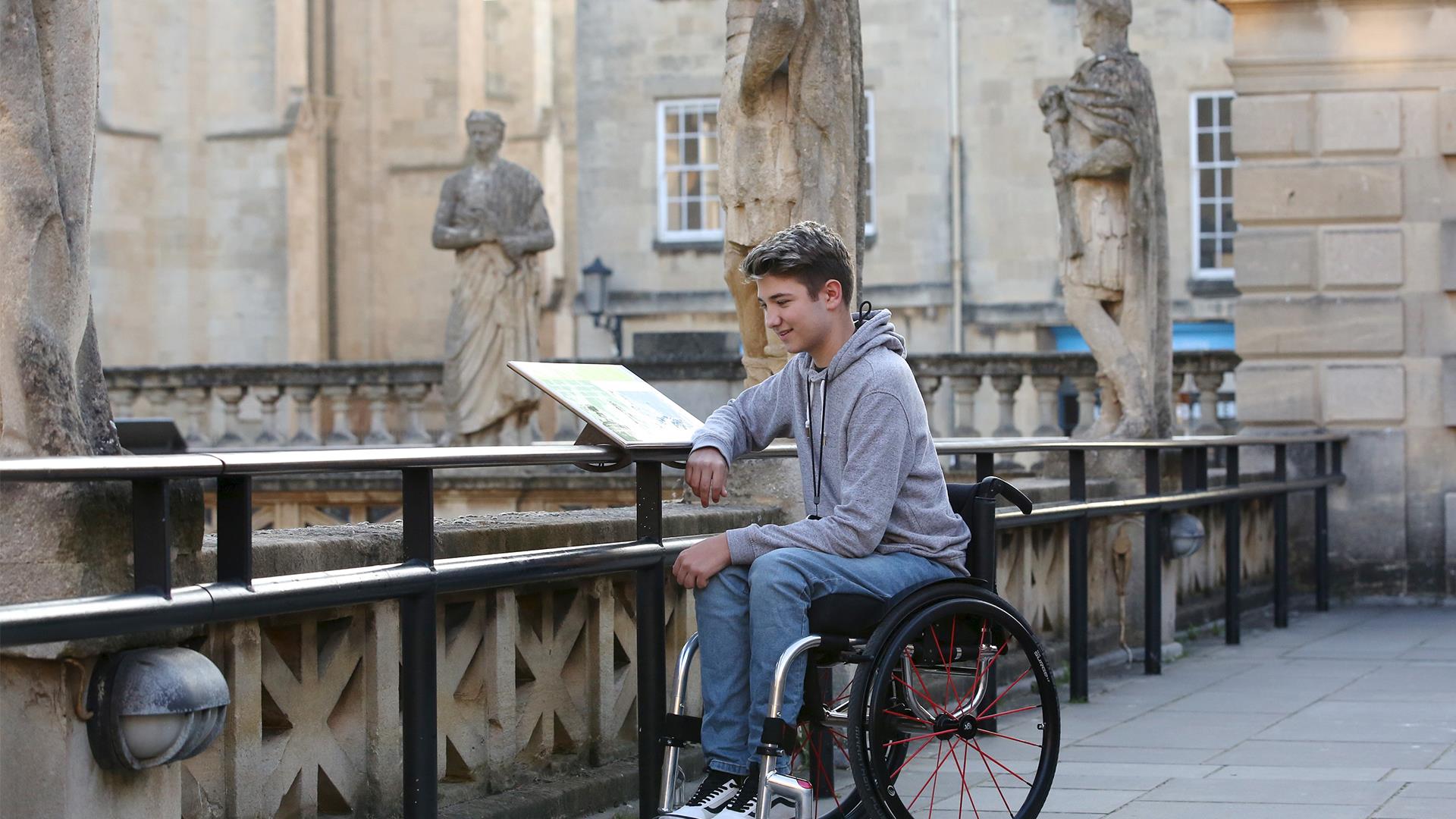 A boy in a wheelchair at The Roman Baths in Bath.